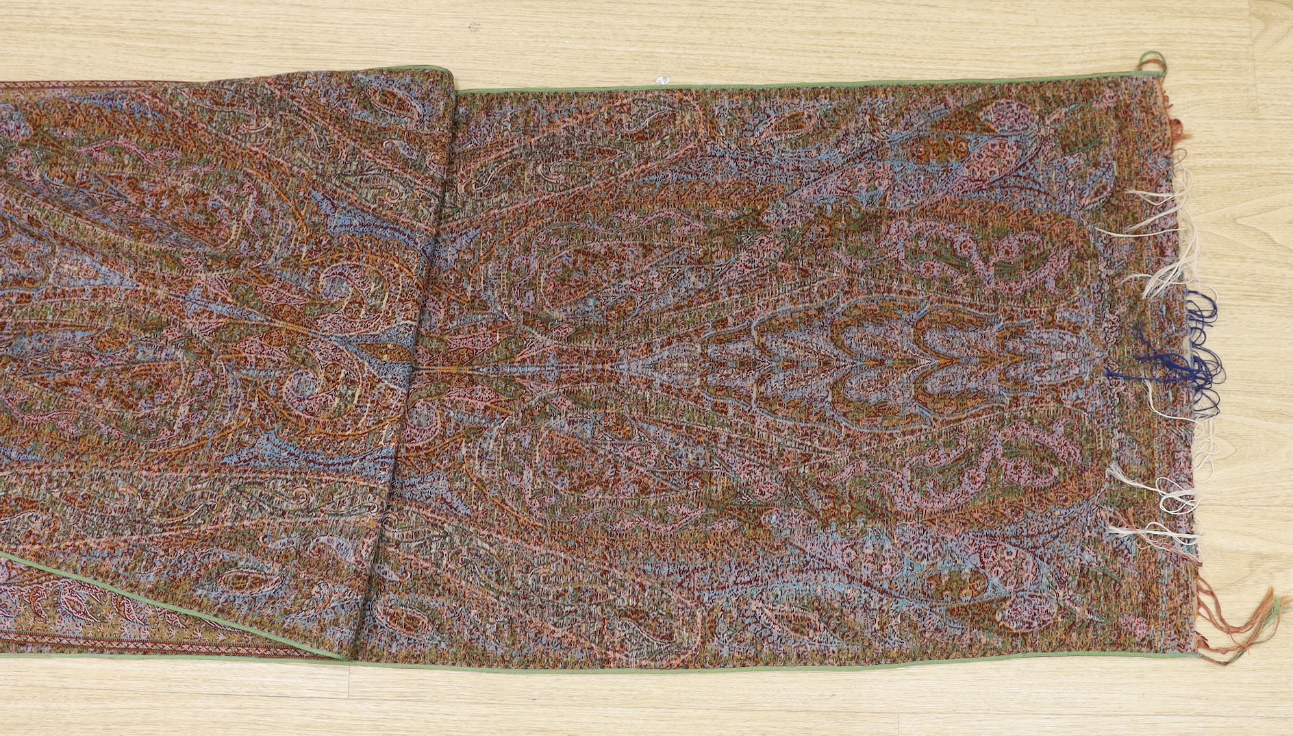 An Indian cream ground paisley stole with un-woven cream centre and heavily woven multicoloured borders and ends, both fringed, 273 x 52cm